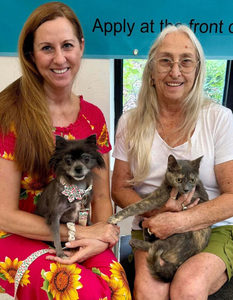 people holding cats and dogs